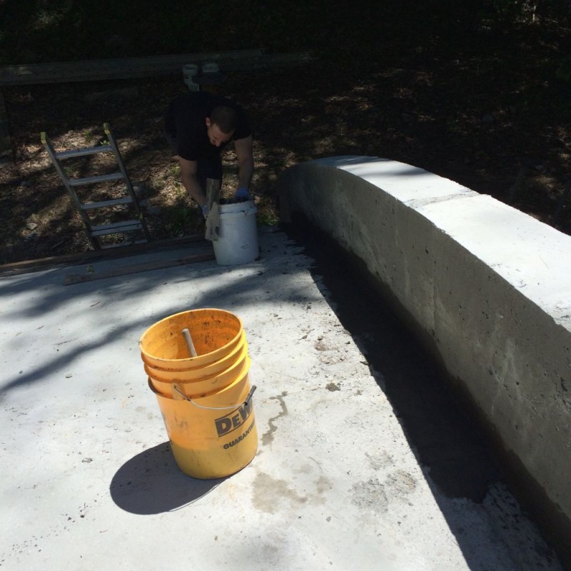 Jeff patching the retaining wall curb where the styrofoam is.