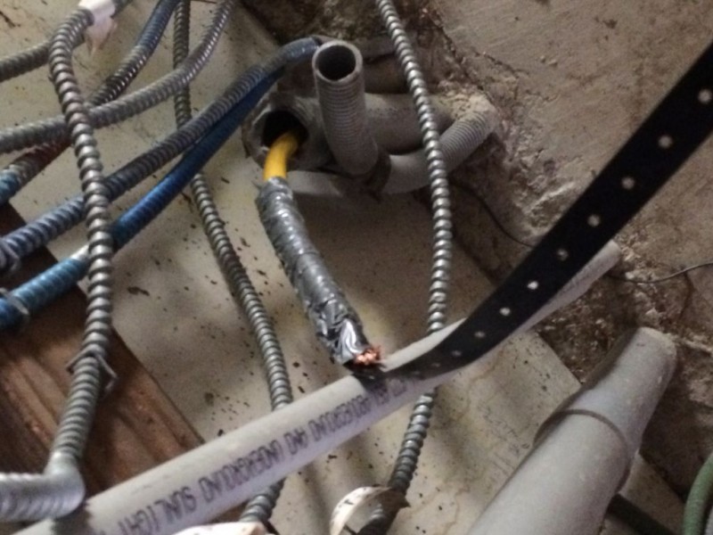 Power cord being pulled through the conduit with some banding wire.